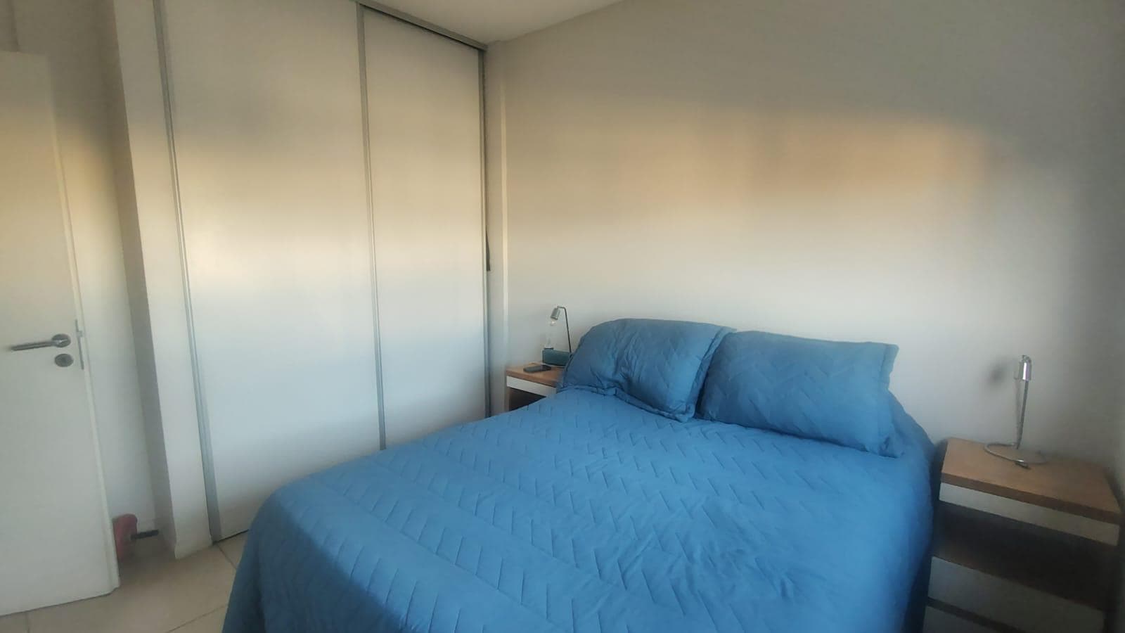 Dormitorio con cama doble, placard y mesas de luz.