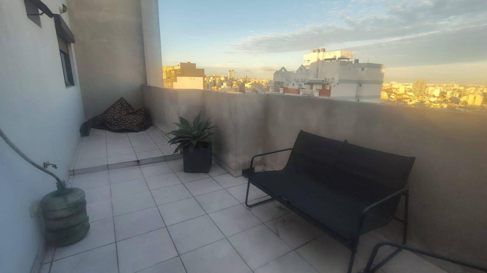 Terraza con mobiliario de exterior y vista panorámica de la ciudad.