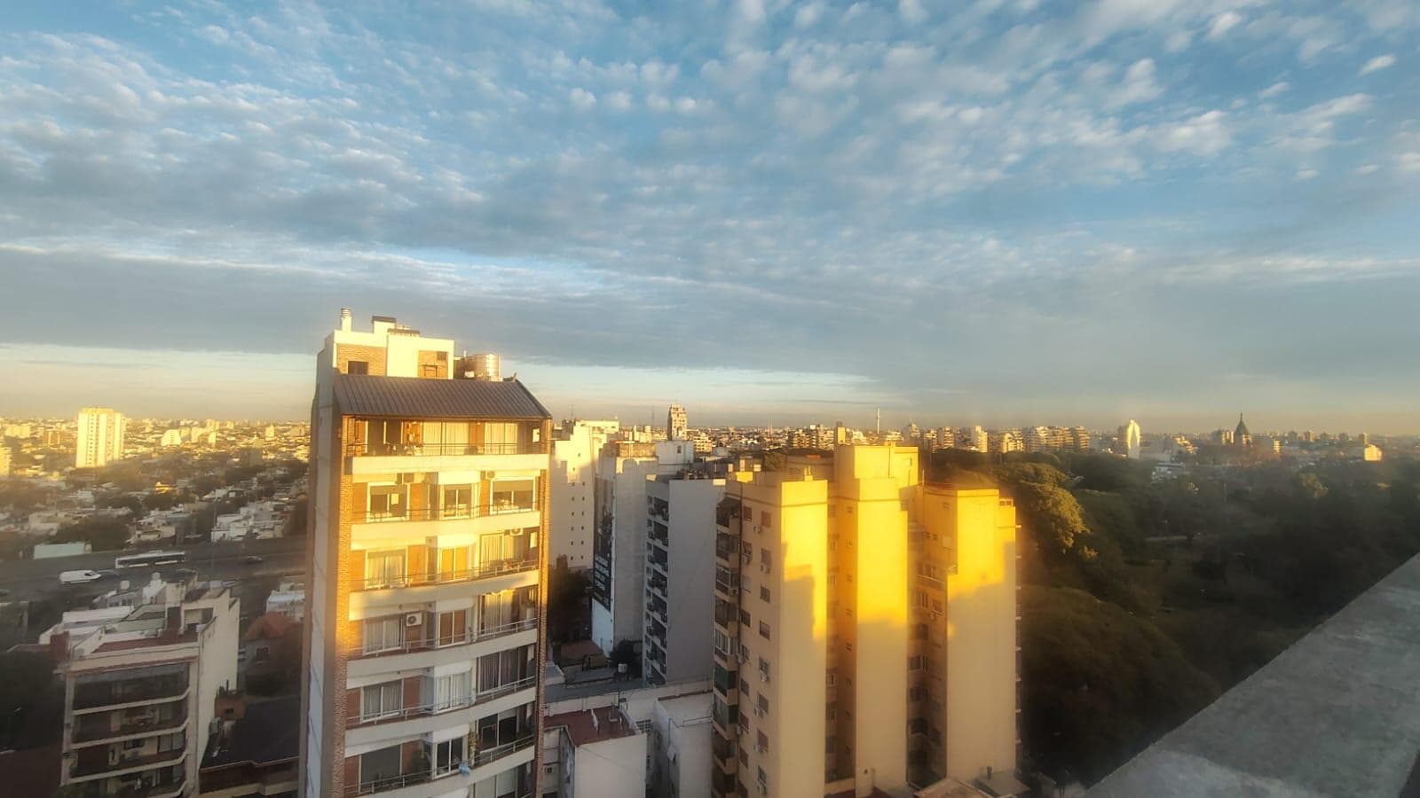 Vista de la ciudad desde la altura con edificios y cielo azul.