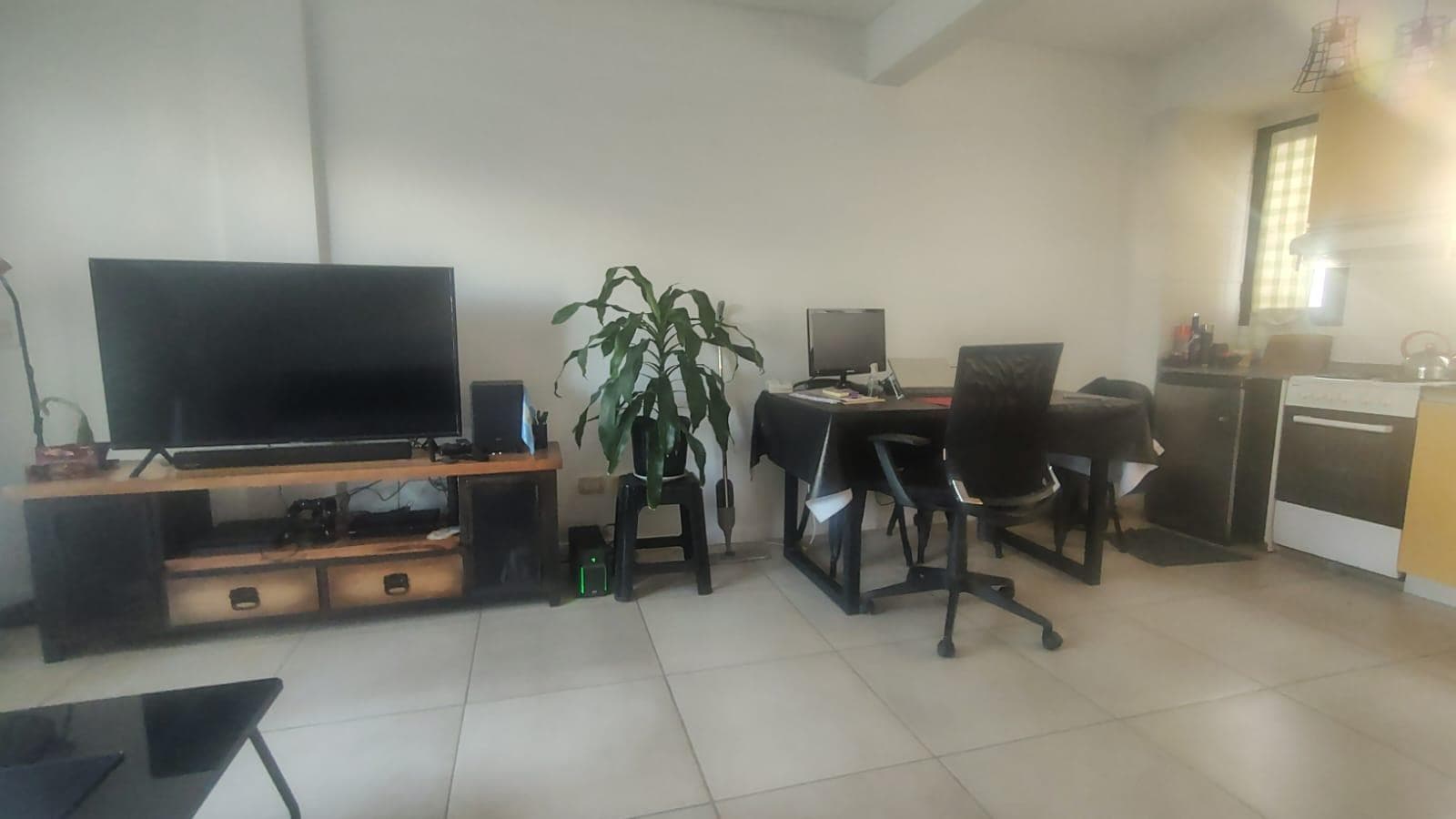 Living-comedor amplio con televisor grande y mesa con sillas.