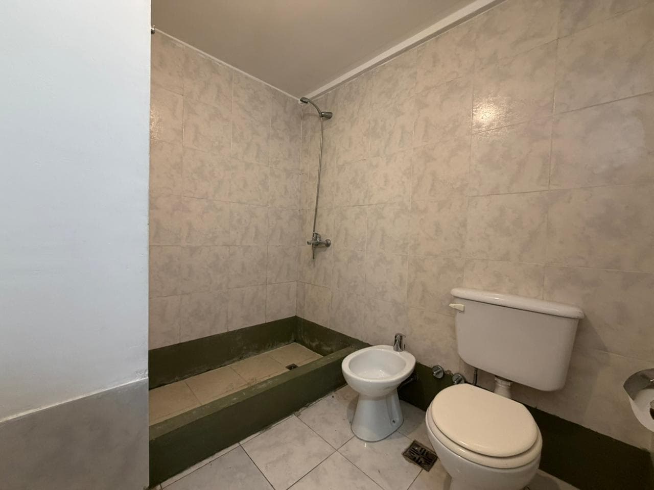 Baño con ducha, inodoro y bidet.