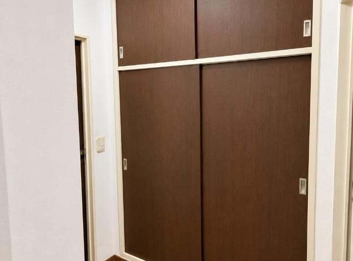Dormitorio vacío con placard marrón de puertas corredizas.