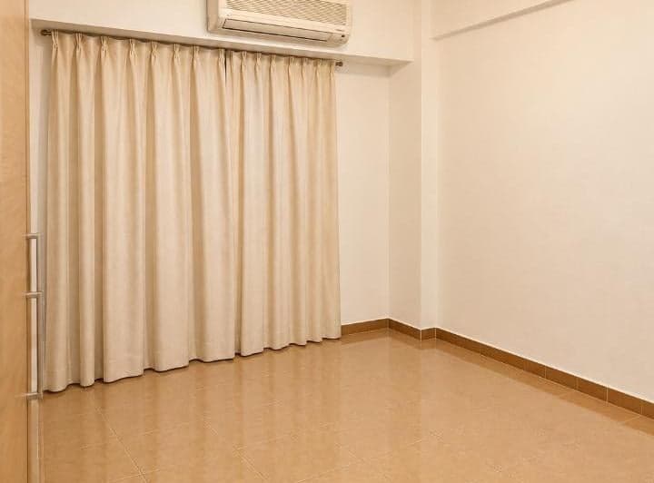 Dormitorio vacío con cortina clara y aire acondicionado.