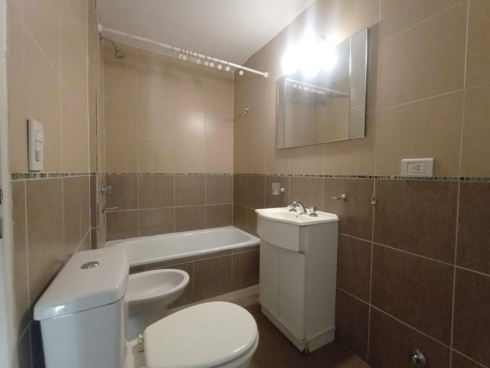 Baño completo con bañera, inodoro, bidet y vanitory.