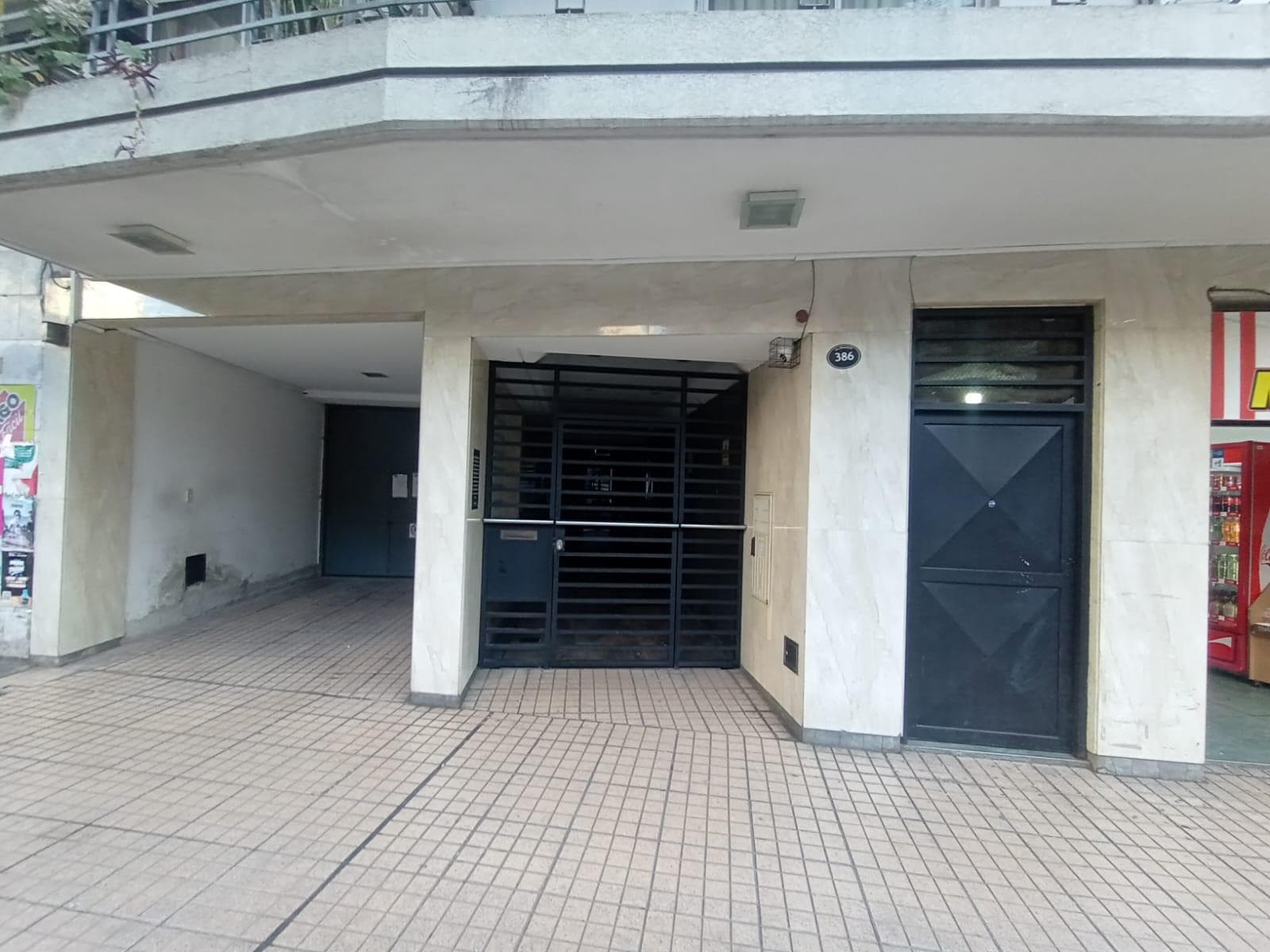 Entrada principal de un edificio con rejas y portón.
