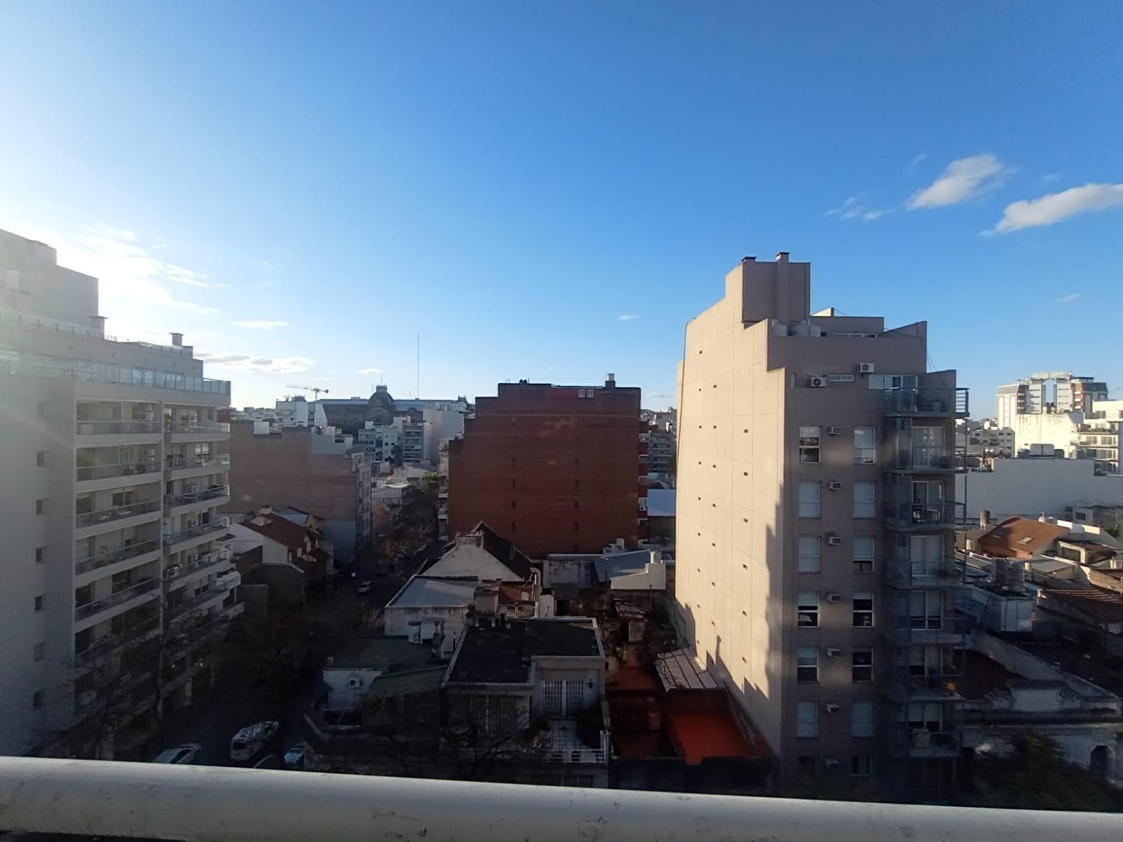 Vista panorámica de la ciudad con edificios y cielo azul.