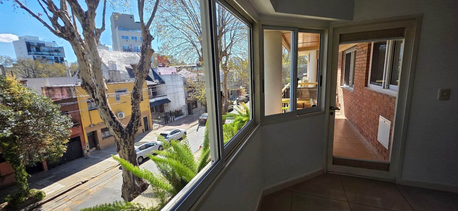 Balcón o terraza con vista a la calle y edificios vecinos.