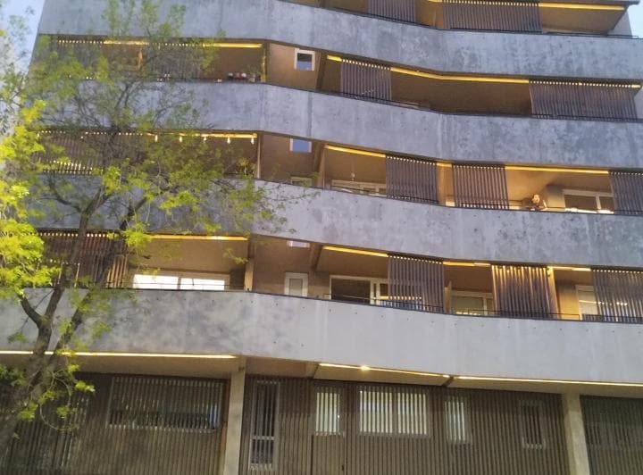 Fachada lateral del edificio con balcones en un día nublado.