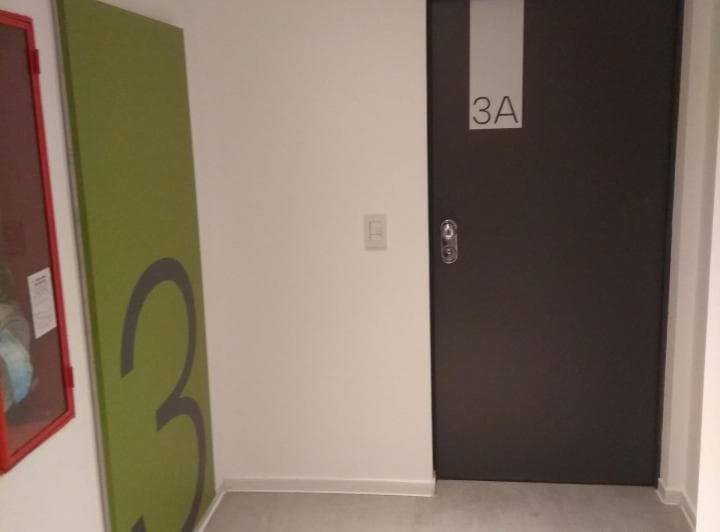 Puerta de un departamento con el número 3A y un diseño con el número tres.