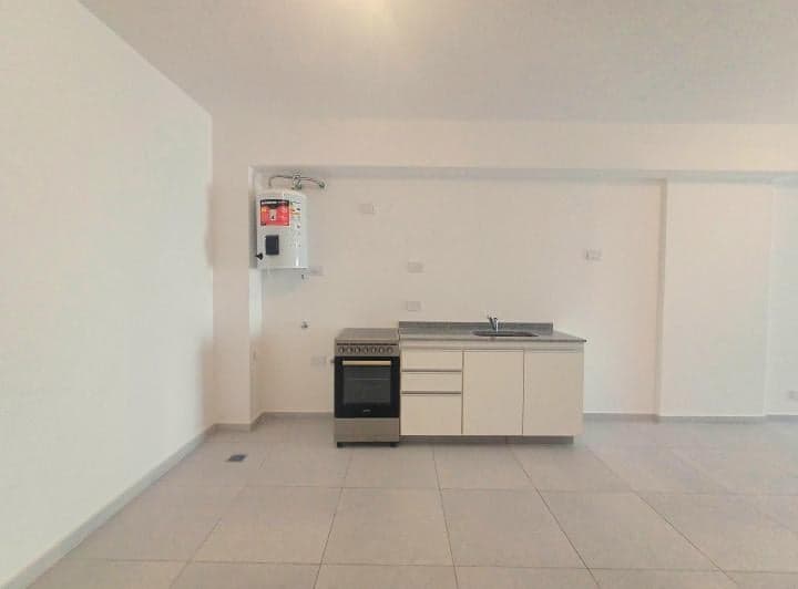 Cocina integrada con termotanque, anafe, bacha y muebles bajo mesada.