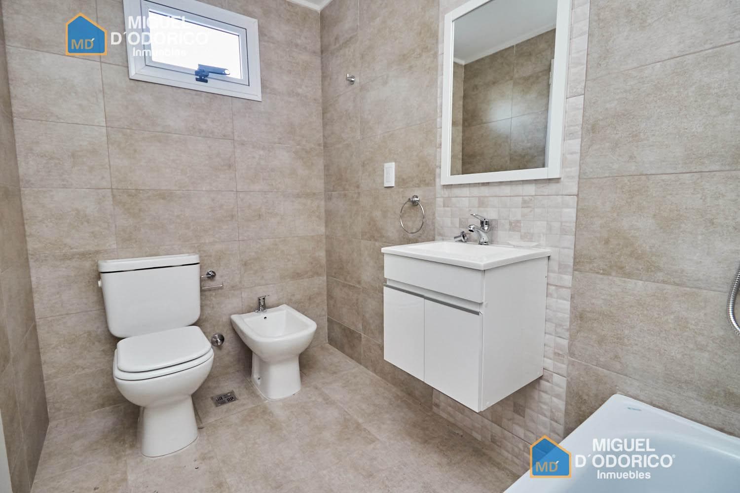 Baño completo con inodoro, bidet, vanitory y bañera.