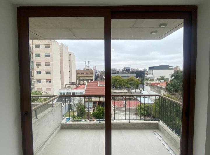 Balcón exterior con baranda de metal y vista a edificios.