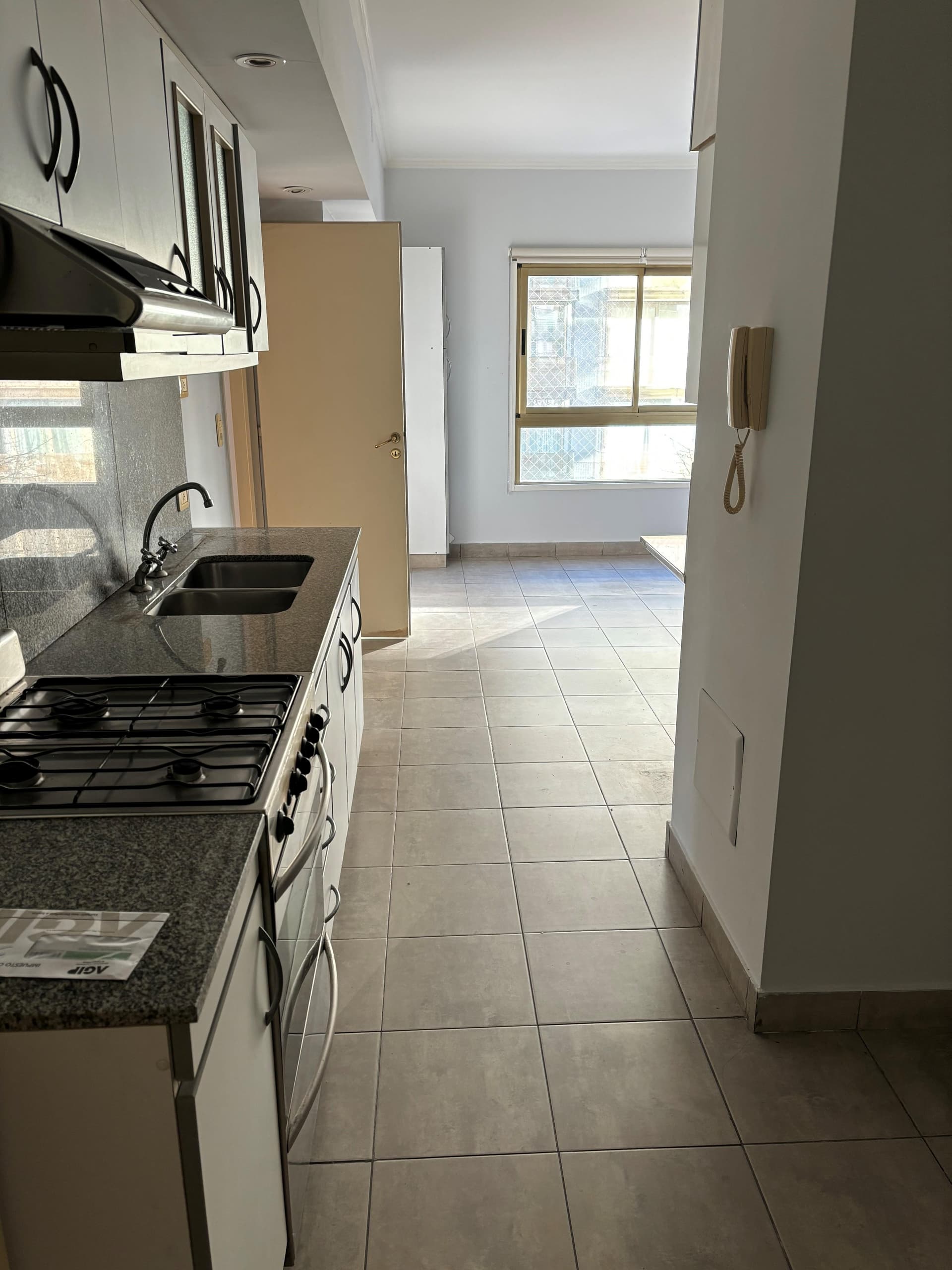 Cocina con mesada de granito y anafe de cuatro hornallas.