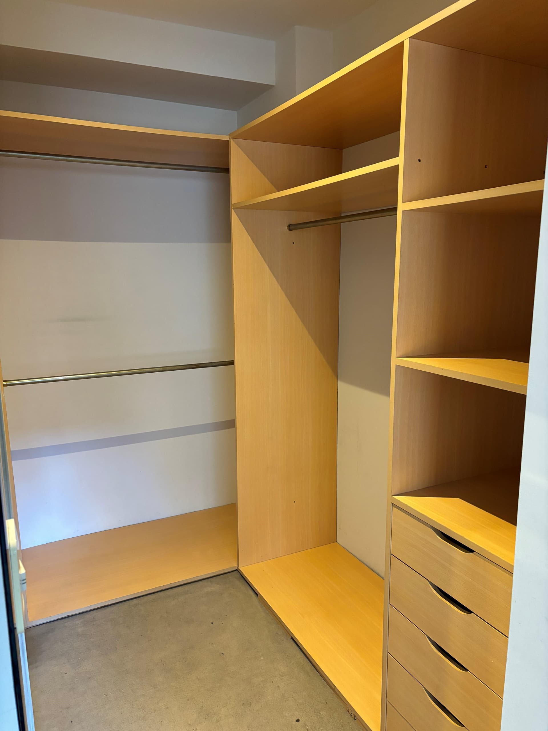 Vestidor empotrado con estantes y cajones de madera.