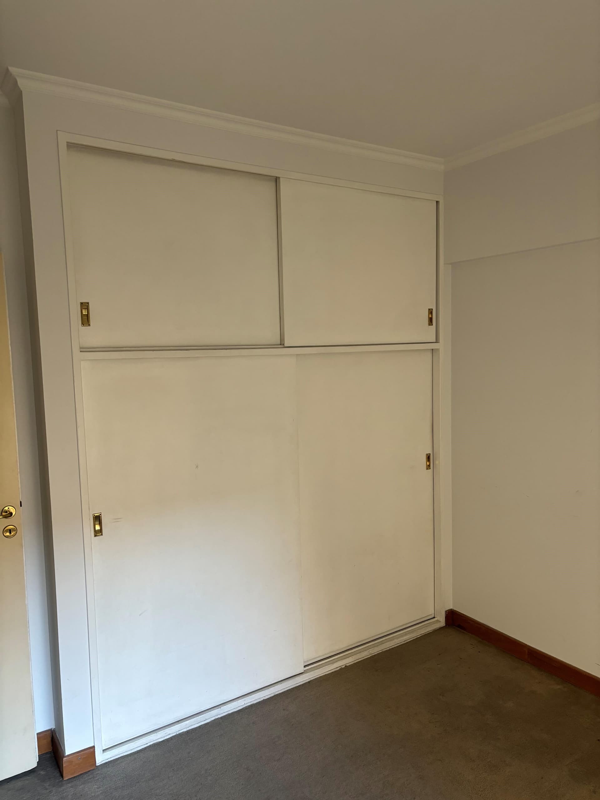 Dormitorio con placard empotrado y alfombra.