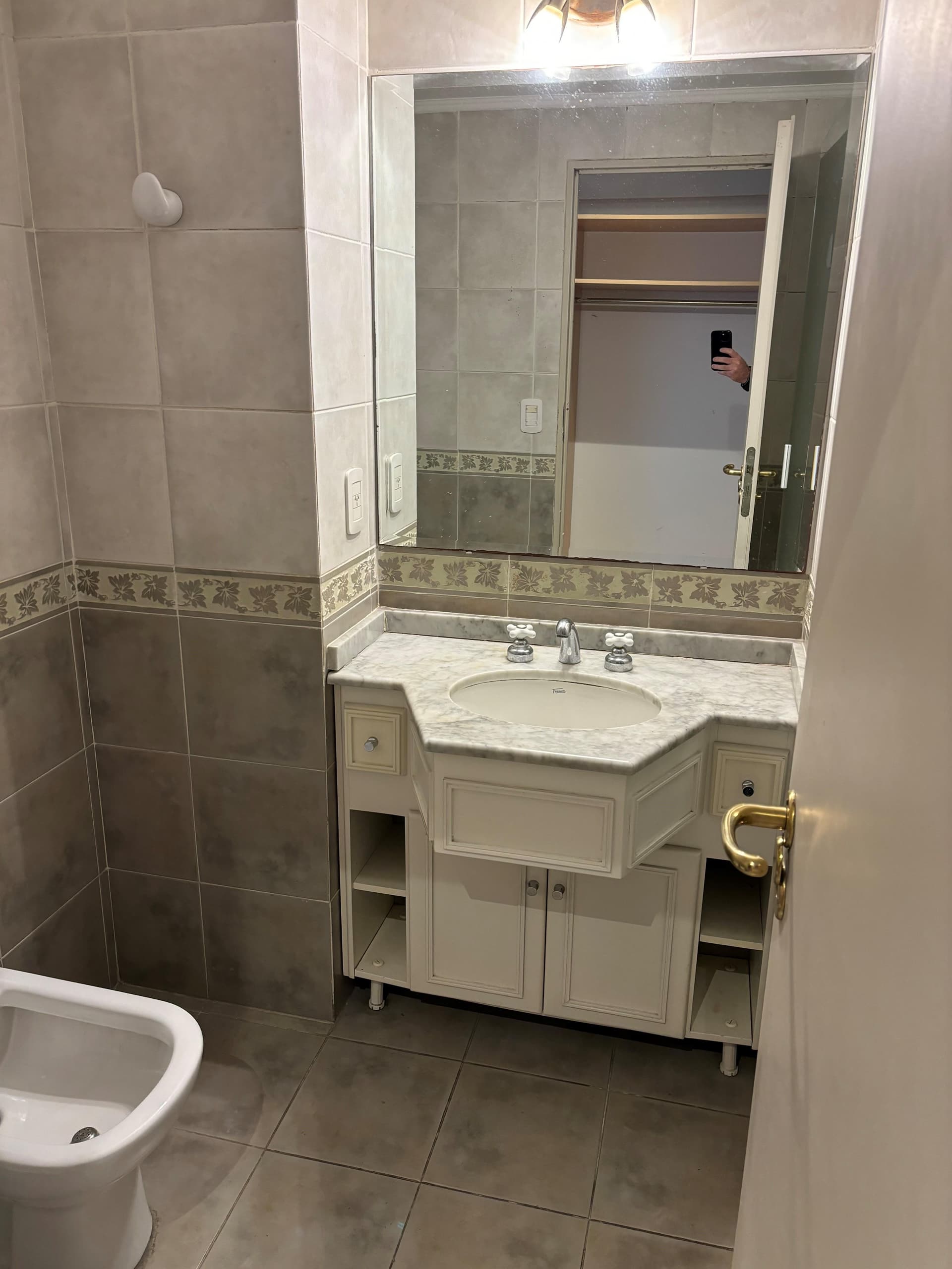 Baño con vanitory de mármol, bidet e inodoro.