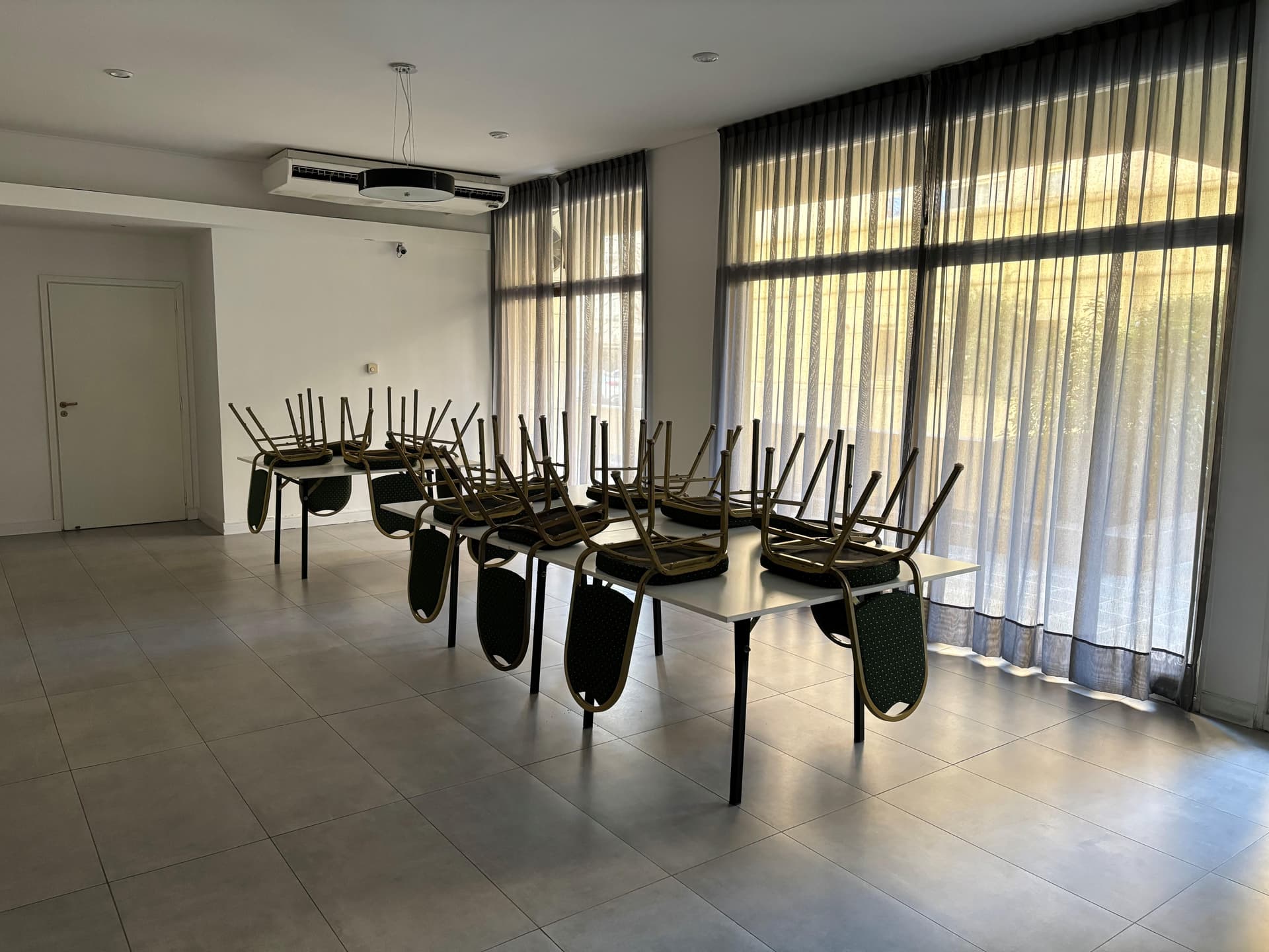 Amplio salón de usos múltiples con grandes ventanales.