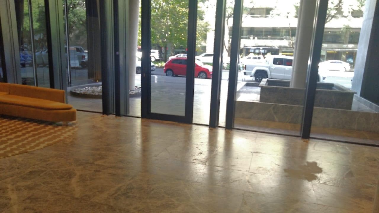 Hall de entrada del edificio con ventanal y vista a la calle.