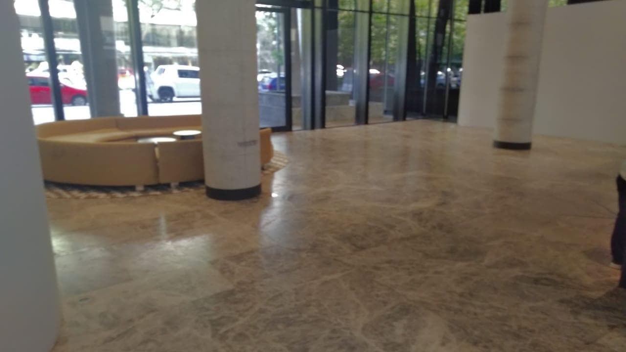Hall de entrada amplio con sillones curvos y columnas de diseño.