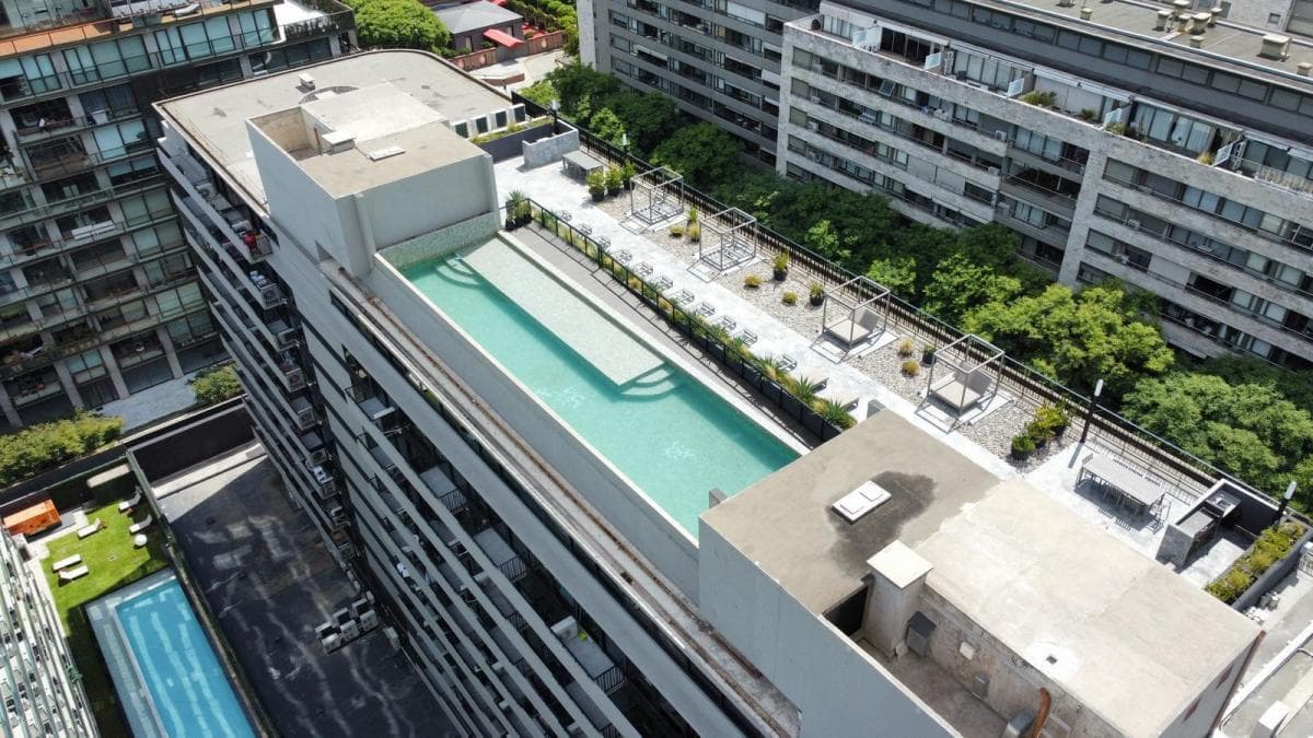 Vista aérea de la pileta y solárium en la terraza del edificio.