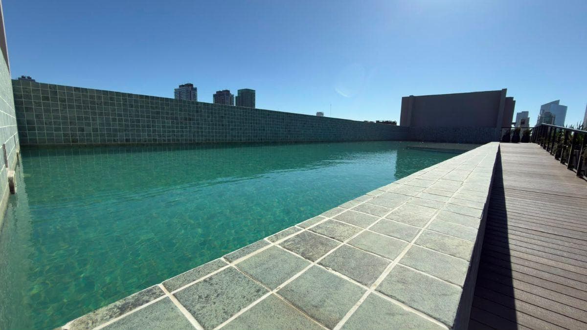 Pileta de natación en la terraza, con azulejos cuadrados azules.