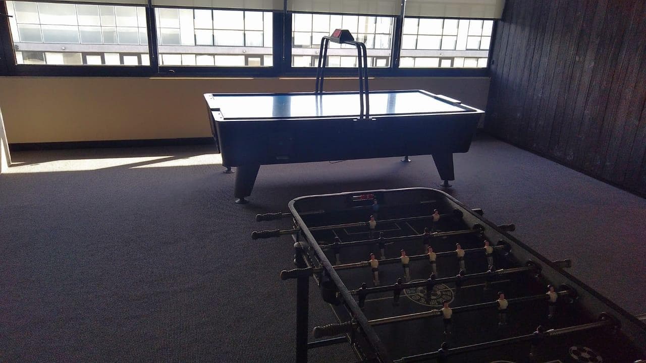 Salón de juegos con mesa de air hockey y metegol.