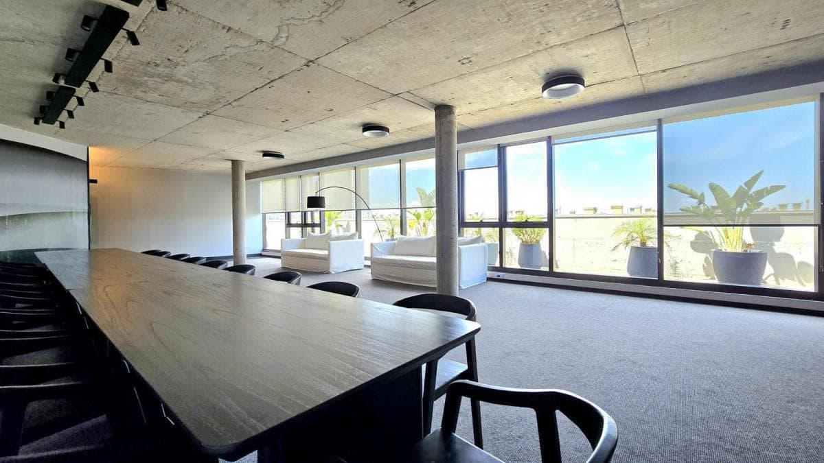 SUM con una mesa de comedor larga y sillones blancos.