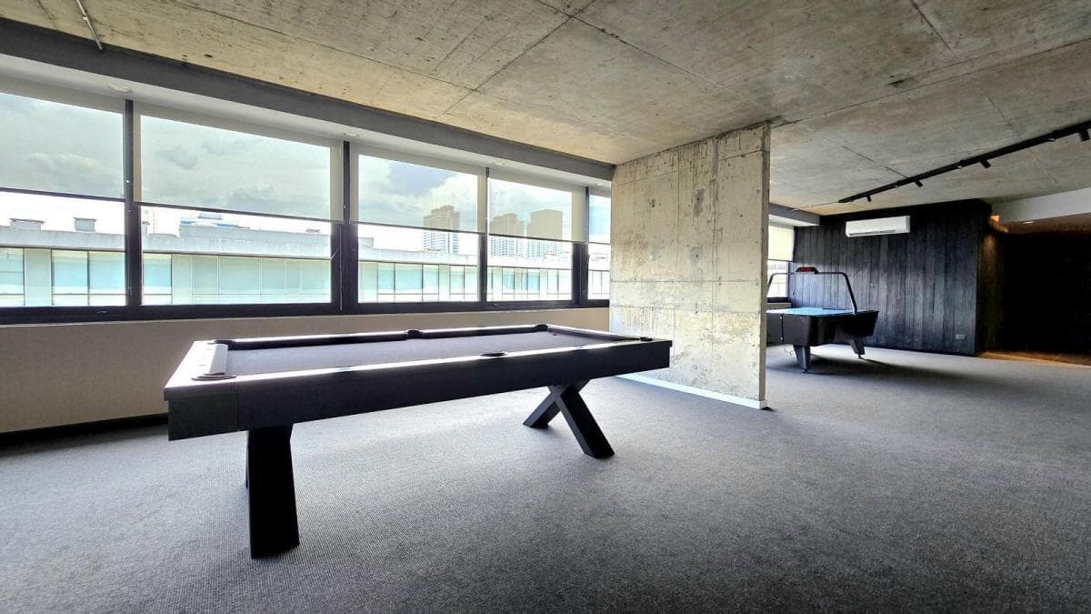 Salón de juegos con dos mesas de pool y metegol.