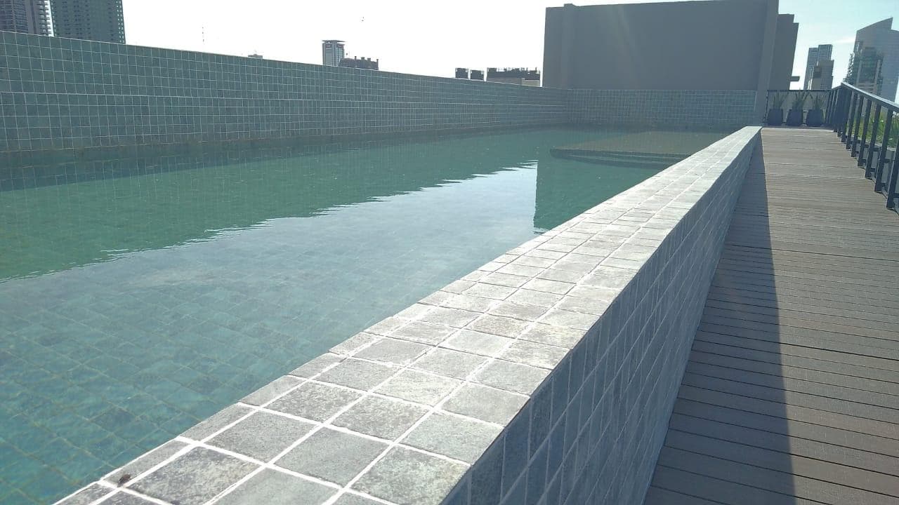 Pileta rectangular en la terraza del edificio con bordes de azulejos.