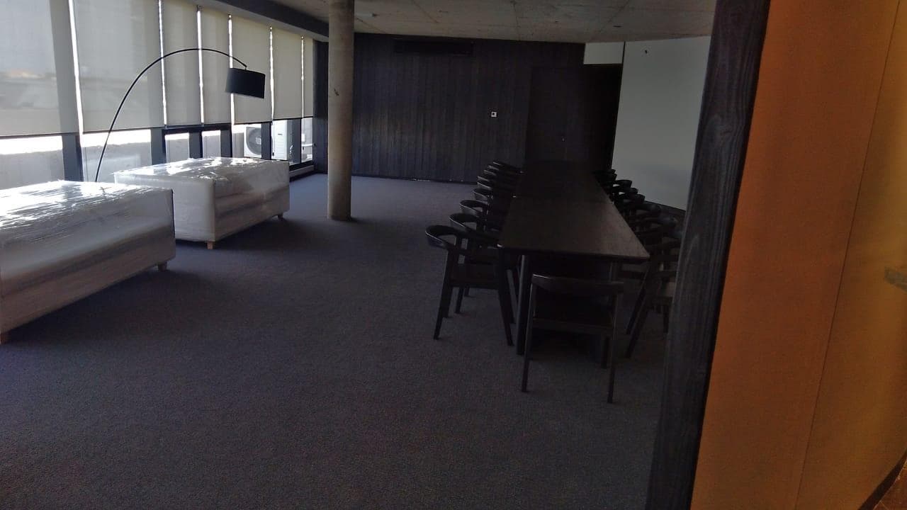 SUM con sillones blancos protegidos y mesa larga para reuniones.