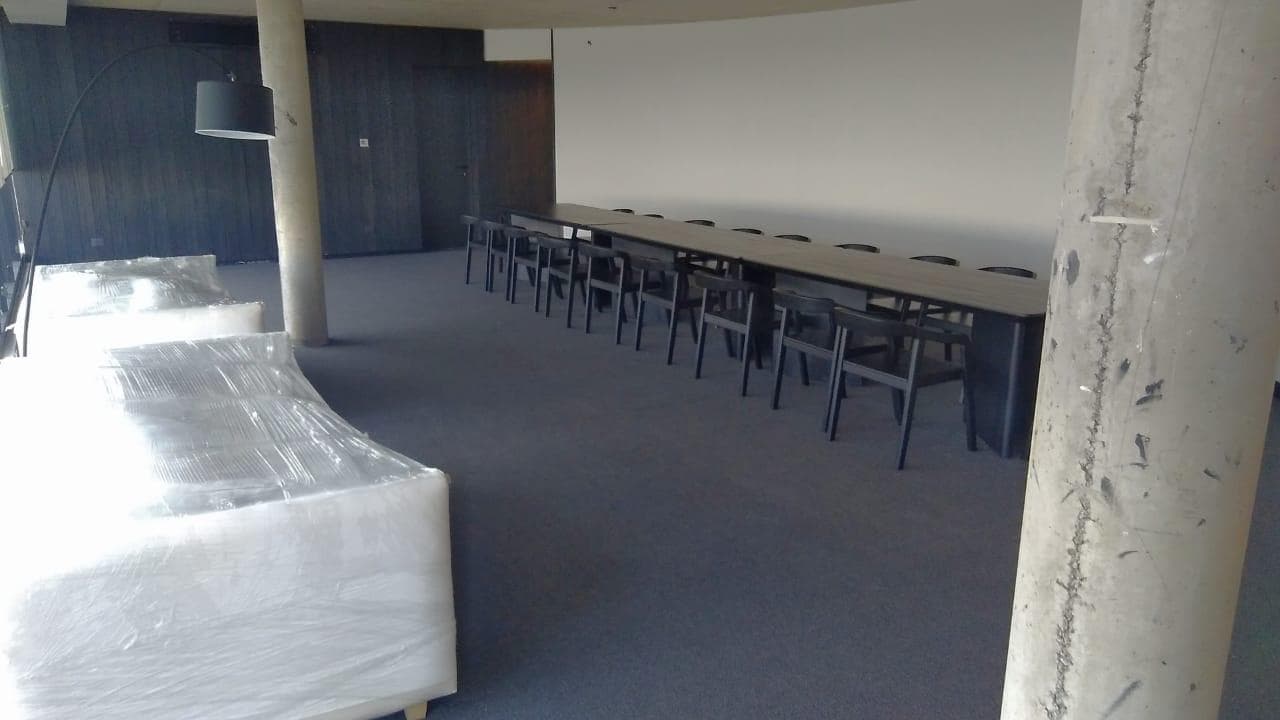 SUM con sillones blancos y una mesa de reuniones oscura.