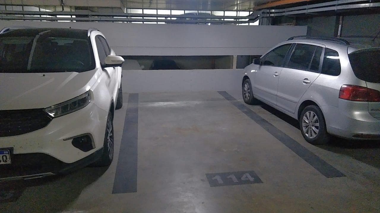 Espacio de cochera numerado para un auto entre otros vehículos.