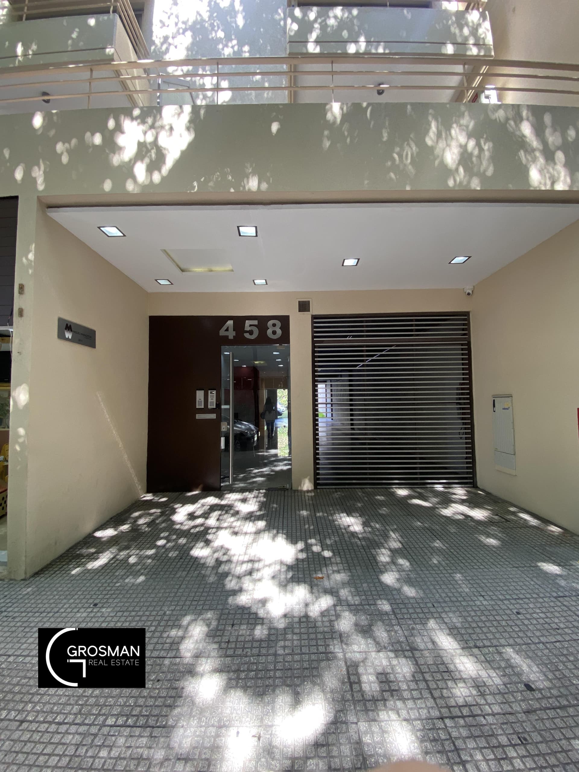 Fachada del edificio con entrada principal y portón de garaje.