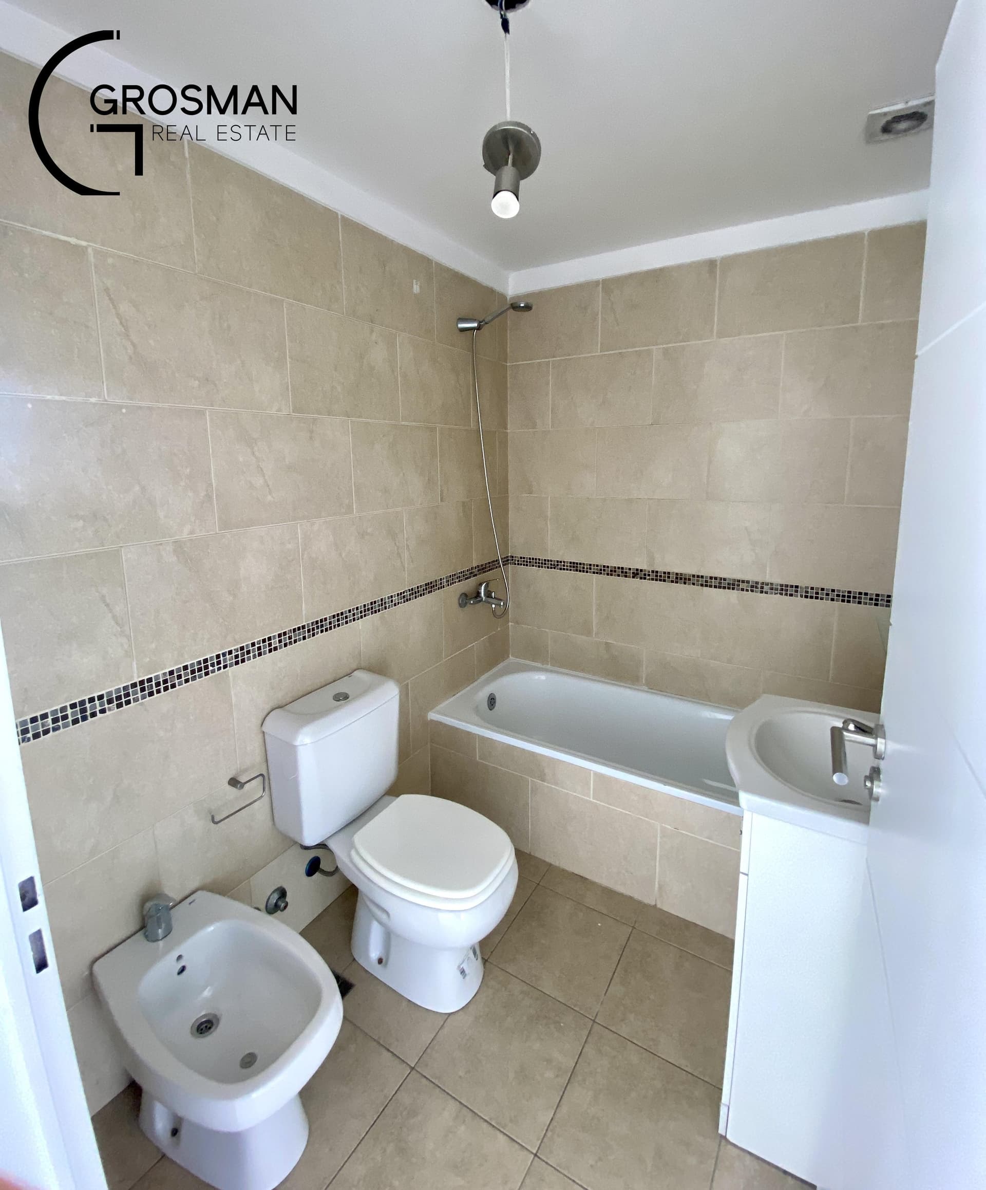 Baño con bañera, inodoro, bidet y vanitory blanco.