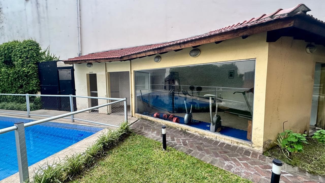 Gimnasio con máquinas de ejercicio, junto a la pileta y el jardín.