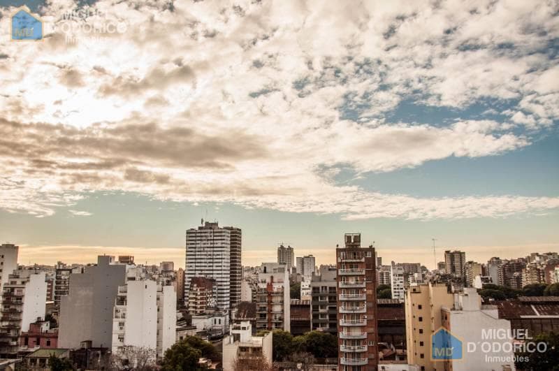 Vista panorámica de la ciudad desde altura, edificios y cielo.