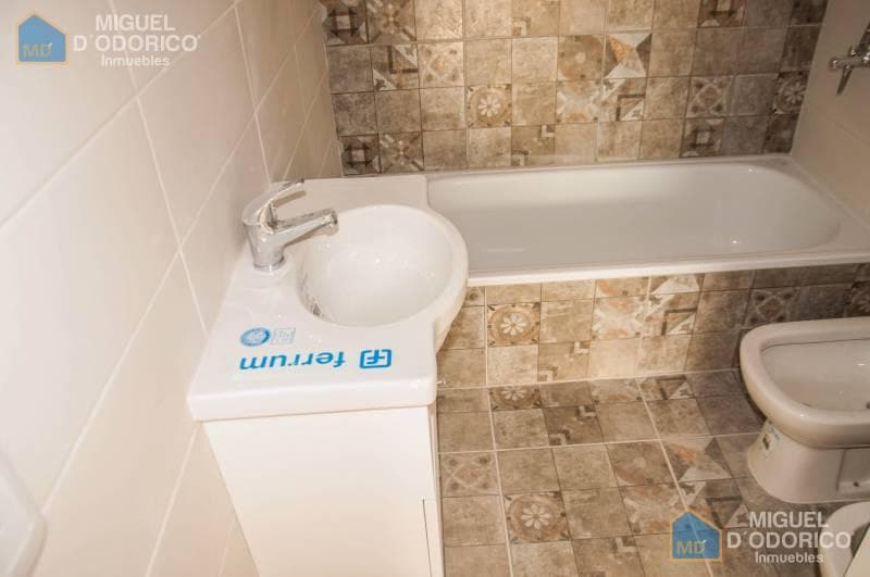 Baño con bañera, bidet, vanitory y azulejos decorativos en la pared.