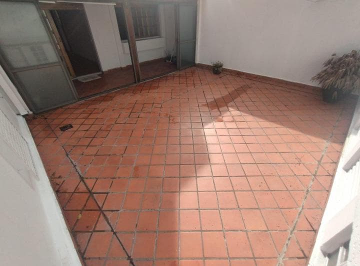 Patio exterior con piso de terracota y puertas corredizas de vidrio.