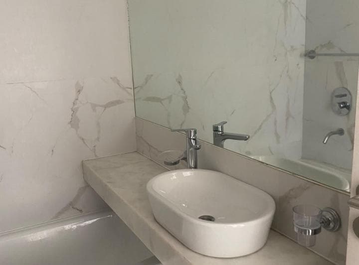 Baño con lavatorio de cuenco, espejo y bañera.