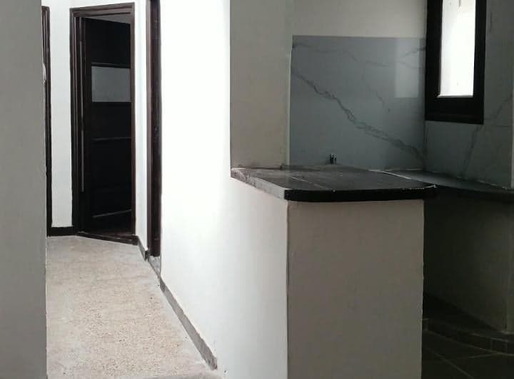 Cocina con barra y vista hacia un pasillo con puertas.