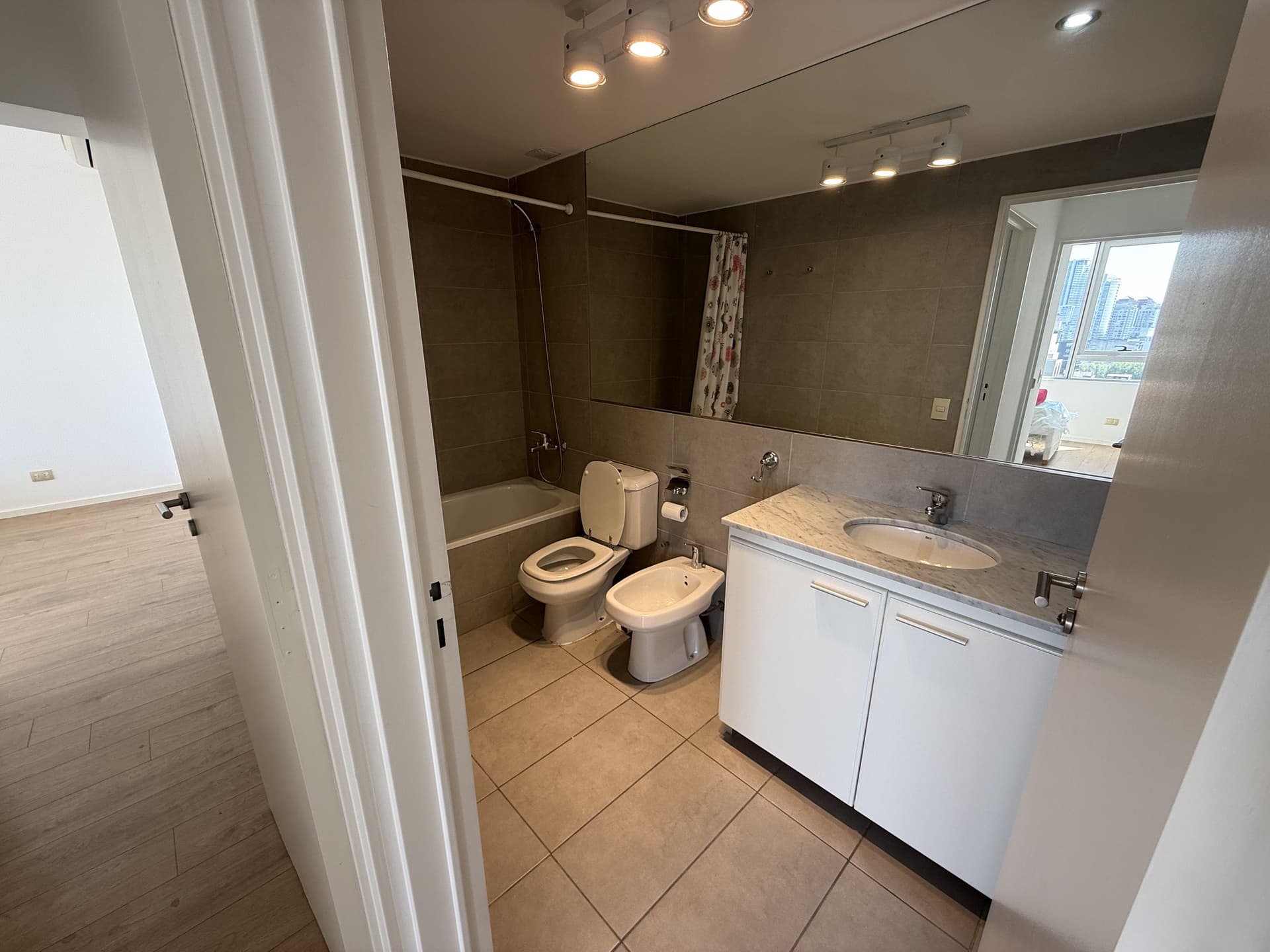 Baño completo con bañera, inodoro, bidet y vanitory con espejo.