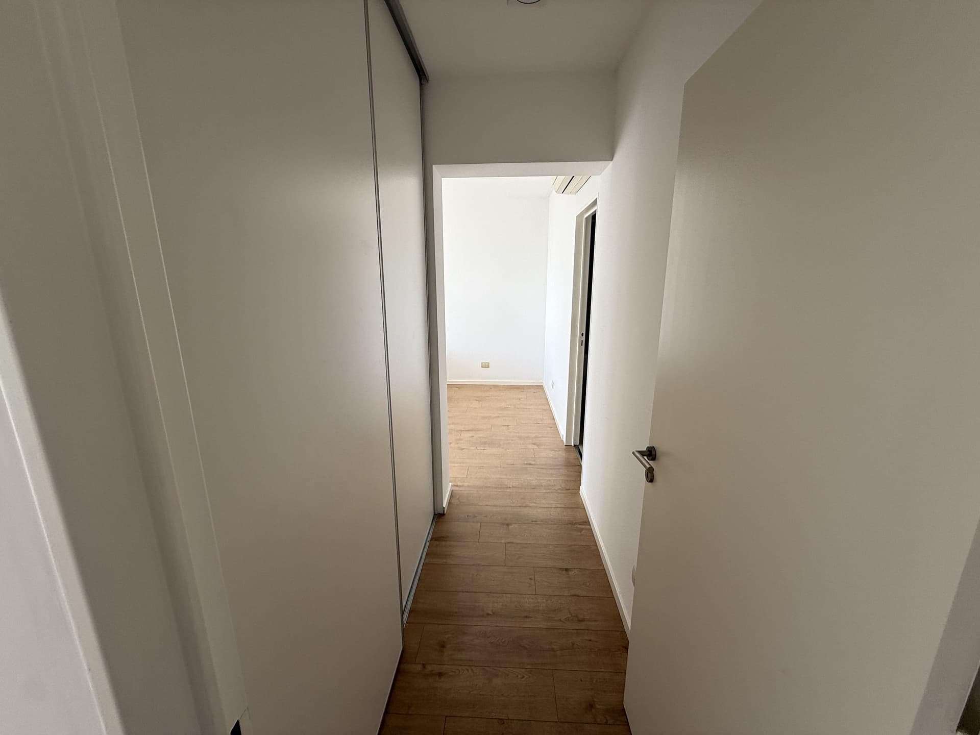 Pasillo con placard empotrado y puertas blancas de acceso a ambientes.