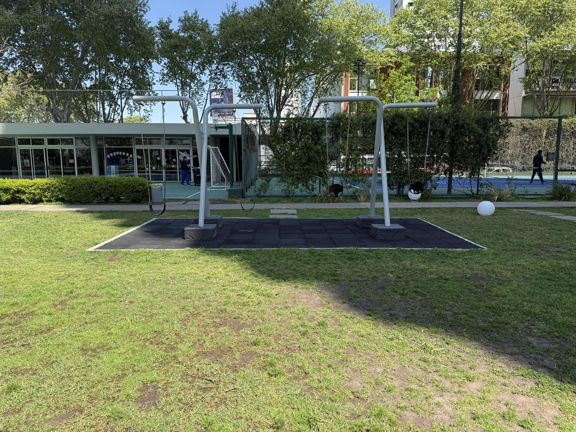 Zona de hamacas para niños en un área verde comunitaria.