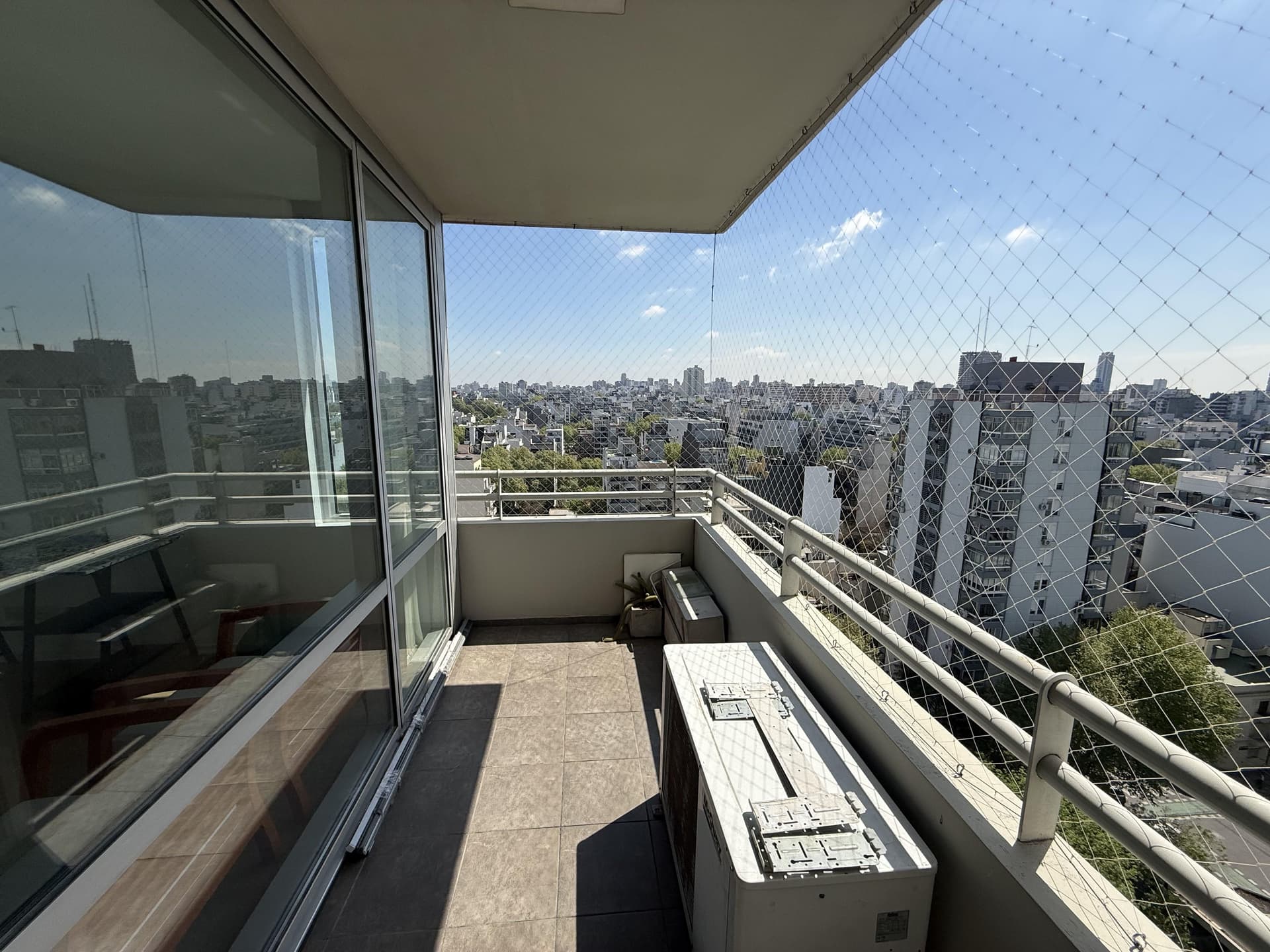 Balcón con red de protección y vista panorámica a la ciudad.