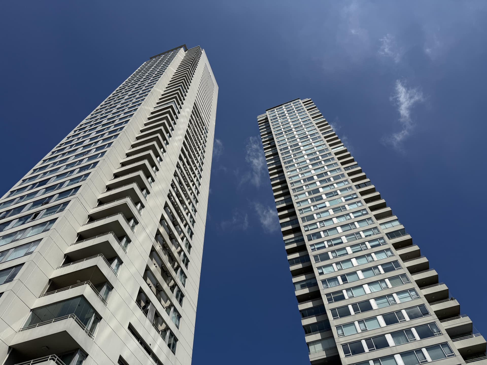 Vista ascendente de dos rascacielos modernos contra el cielo azul.