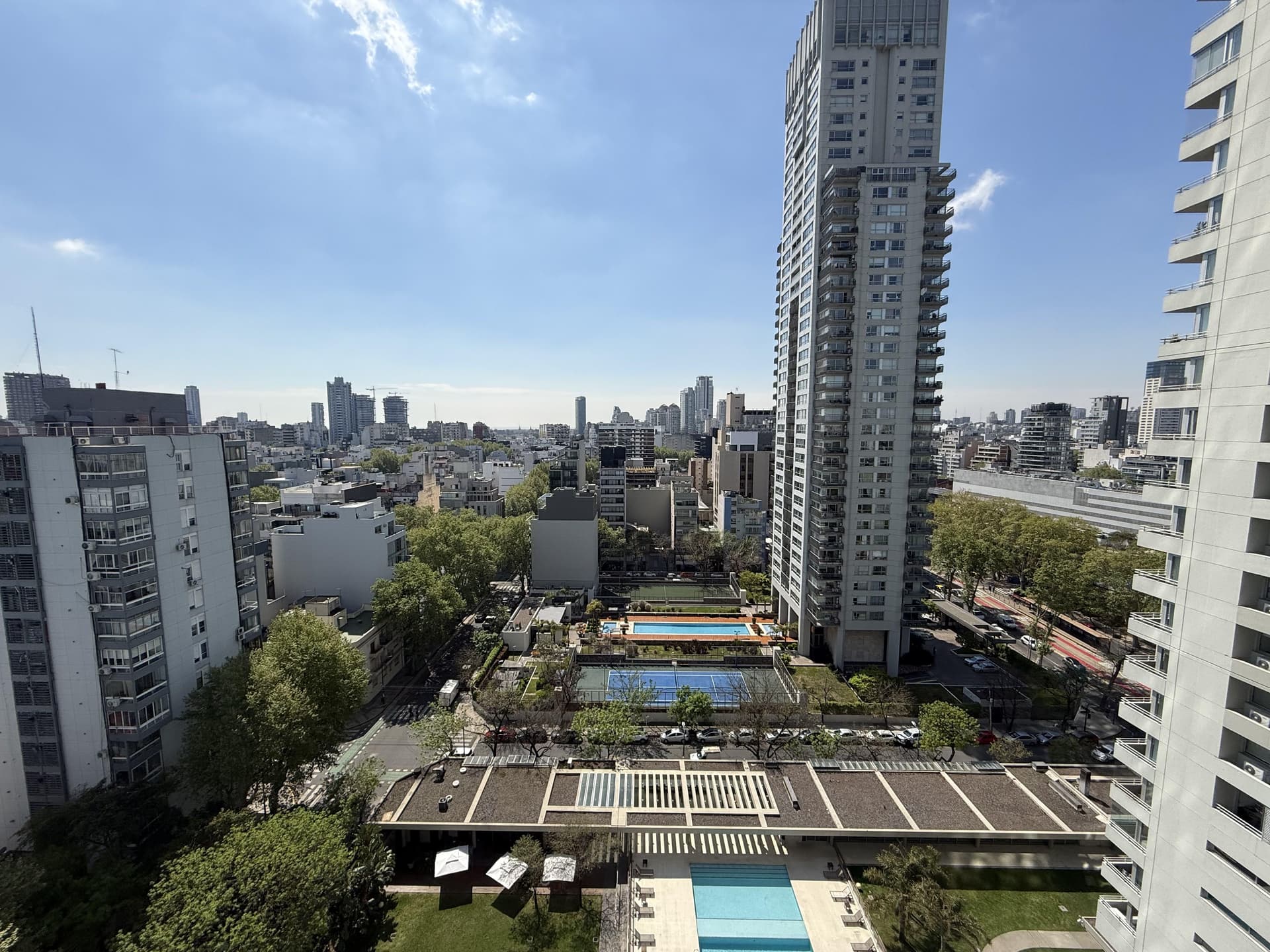 Vista panorámica de la ciudad con edificios altos y piscinas.
