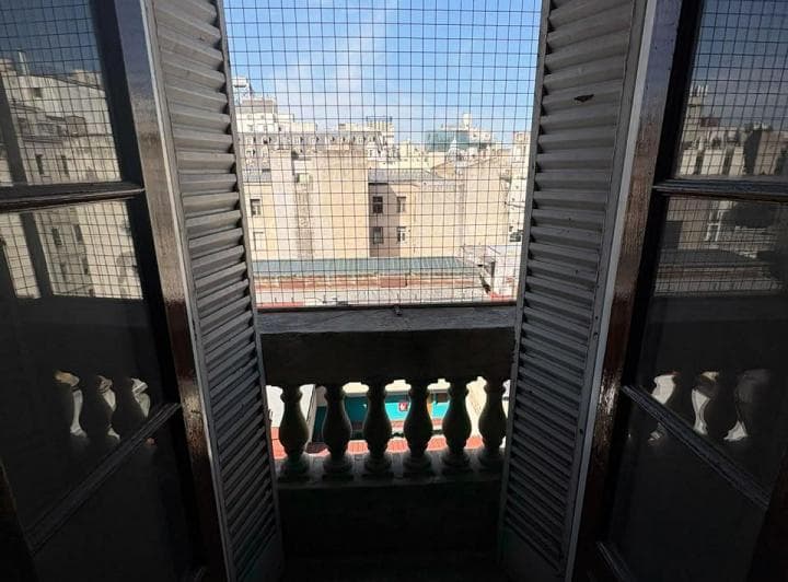 Vista de la ciudad a través de las rejas de un balcón.