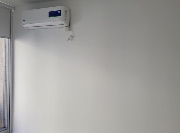 Detalle de pared blanca con equipo de aire acondicionado split.