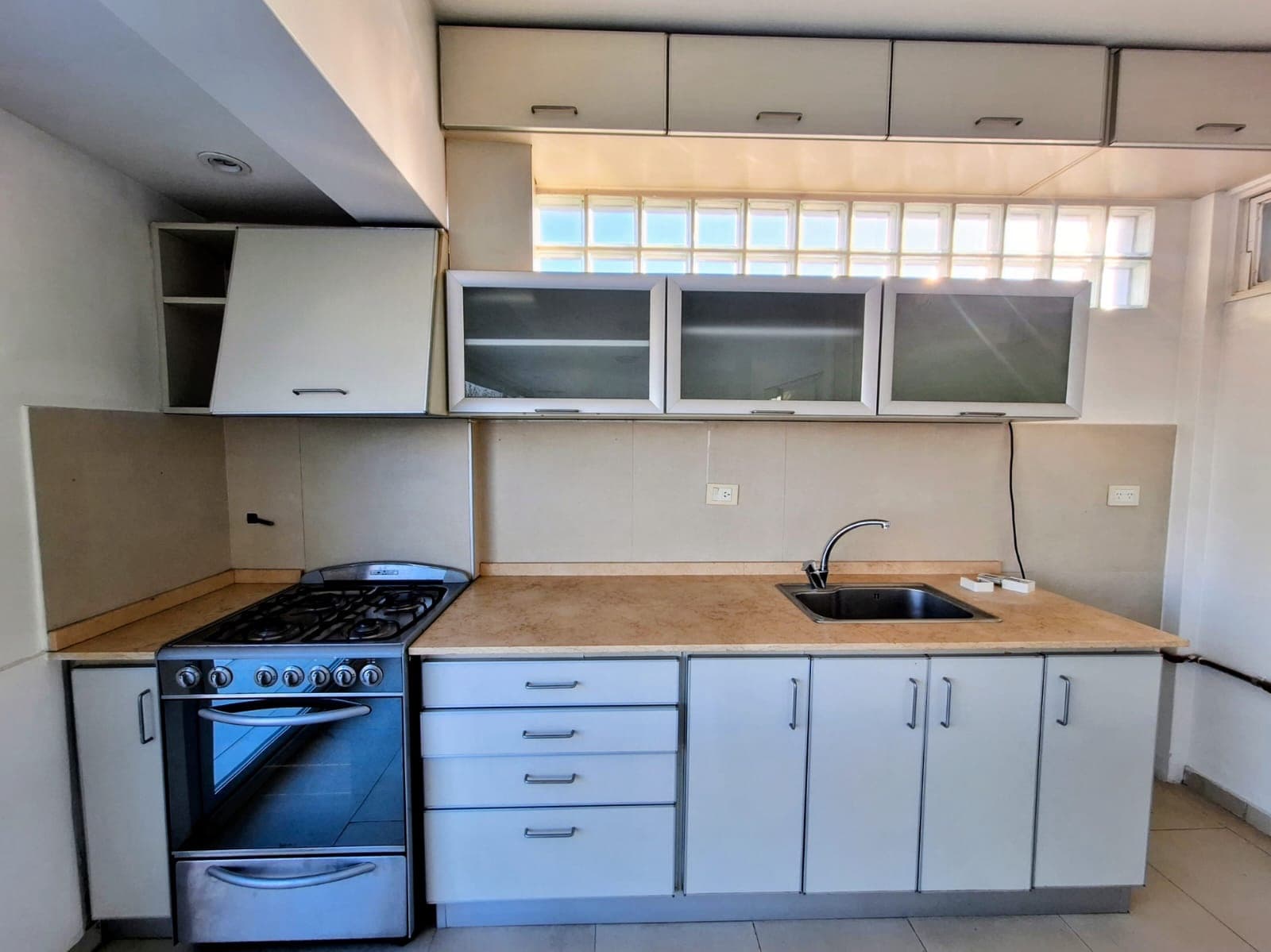 Cocina con mesada, bacha, anafe y alacenas superiores e inferiores.