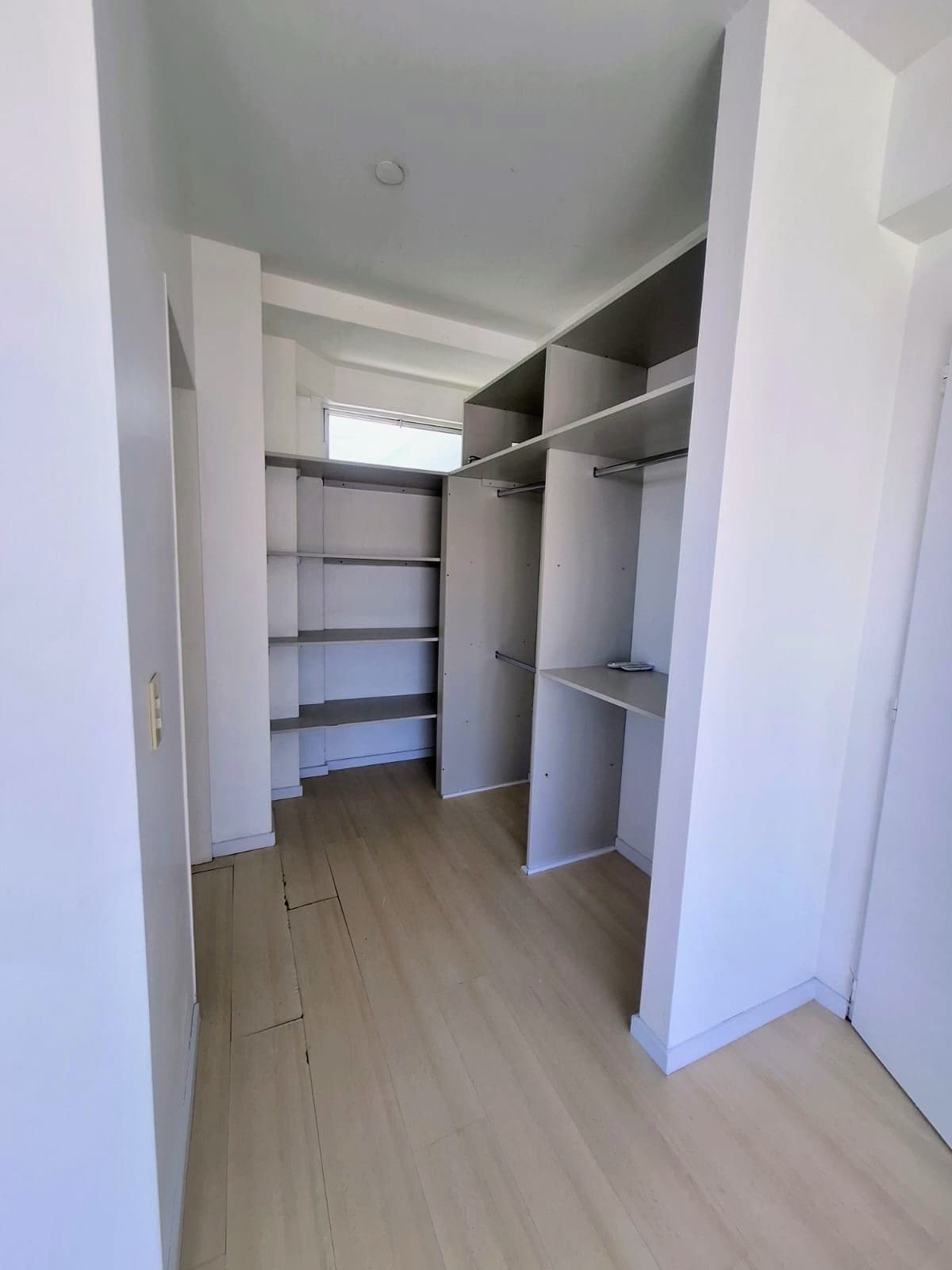 Vestidor empotrado con estantes y compartimentos de guardado.